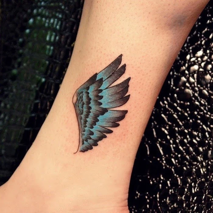 black and blue wing, ankle tattoo, black leather chair, angel wings tattoo