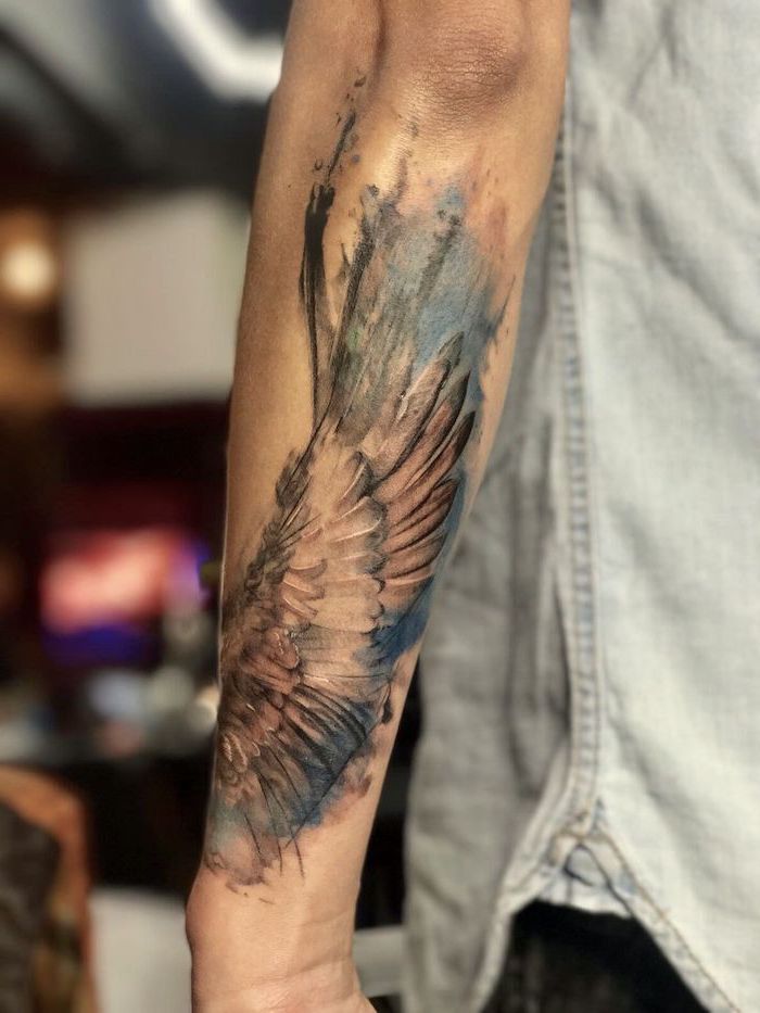 man with denim shirt, forearm tattoo, watercolor tattoo, guardian angel tattoo, blurred background