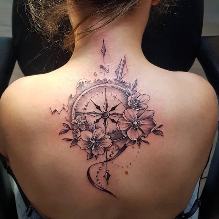 back tattoo, nautical compass tattoo, surrounded by flowers, east and north, girl with blonde hair