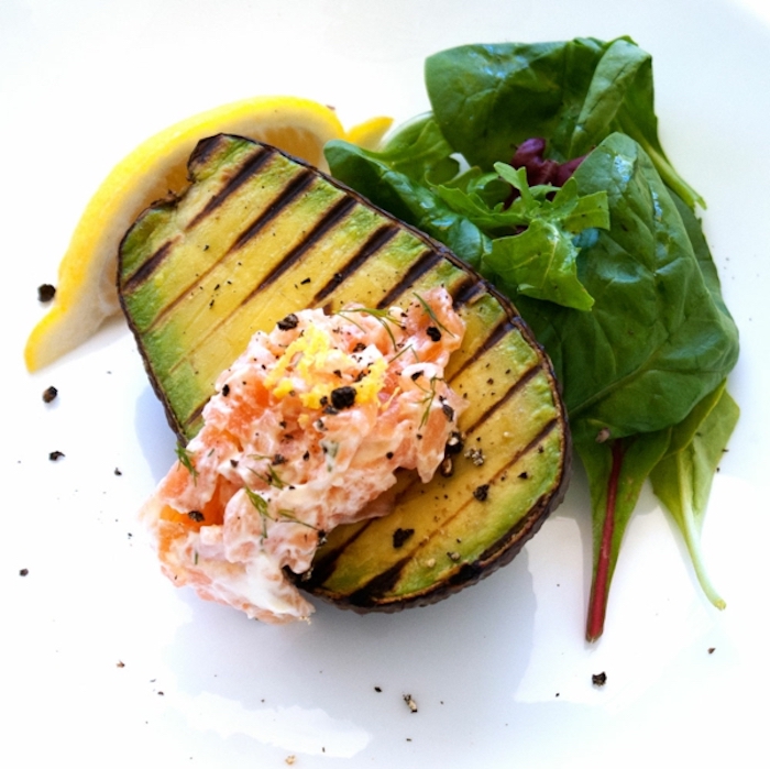 halved baked avocado, filled with coleslaw, green salad, lemon slice, brunch menu