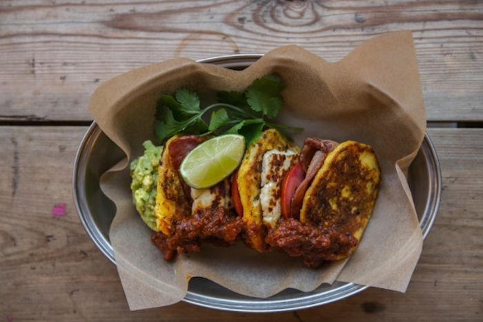 baked cheese, with bacon and tomatoes, guacamole side, brunch menu, silver tray, wooden table