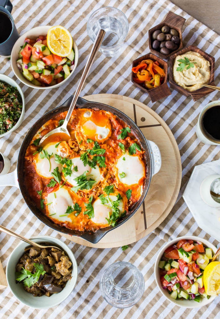 baking pan, eggs with tomato sauce, wooden board, brunch ideas, bowls of different garnish