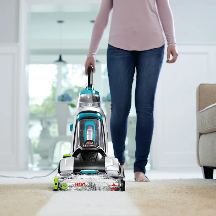 best vacuum cleaner, woman cleaning, wearing jeans, pink blouse, white carpet