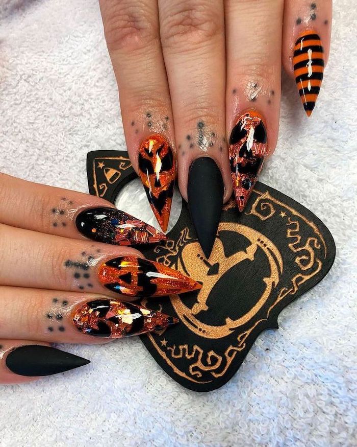 halloween acrylic nails, black matte nail polish, orange pumpkin decorations, long stiletto nails