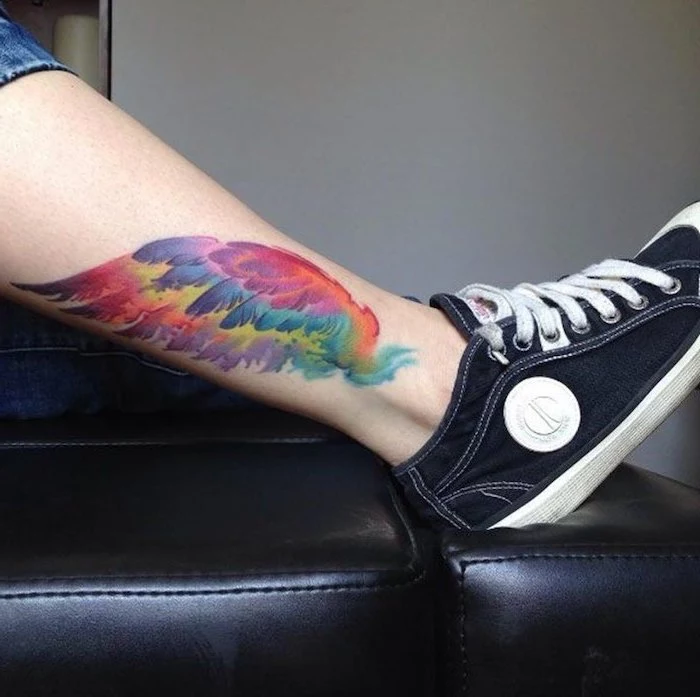 black sneakers, black leather chair, wings tattoo on back, watercolor tattoo, leg tattoo, white background