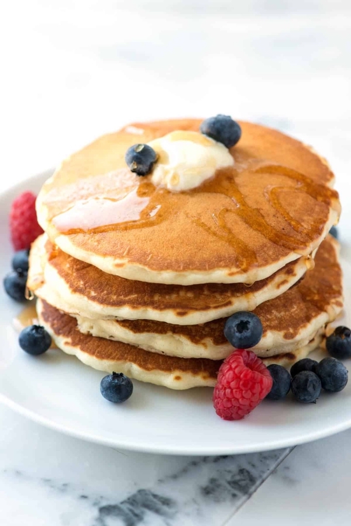 pancakes stack, butter and honey on top, blueberries and raspberries, breakfast dishes