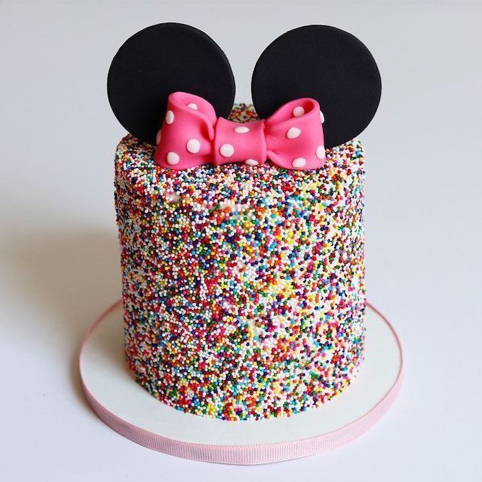 minnie mouse cake, covered in sprinkles, pink bow, black ears, white background