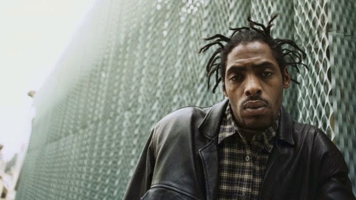 coolio leaning on a wall, wearing a black leather jacket, box braids men, flannel shirt