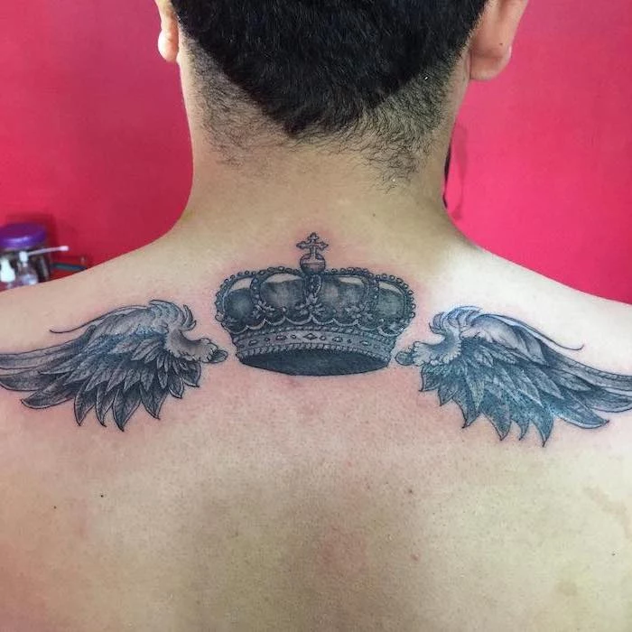 pink background, angel wings, crown in the middle, small angel wings tattoo, man with black hair