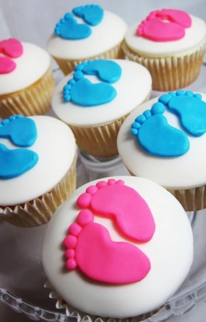 gender reveal party ideas, small cupcakes, white frosting, pink and blue, baby footprints, made of fondant