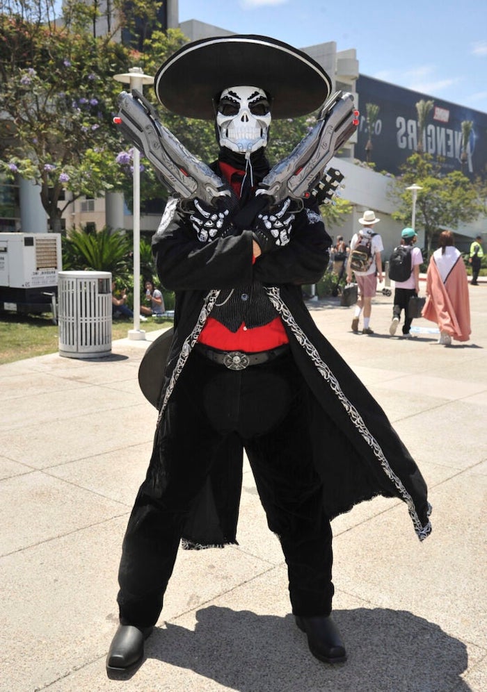 man with sombrero, black coat, red shirt, black pants, halloween costumes, holding two guns
