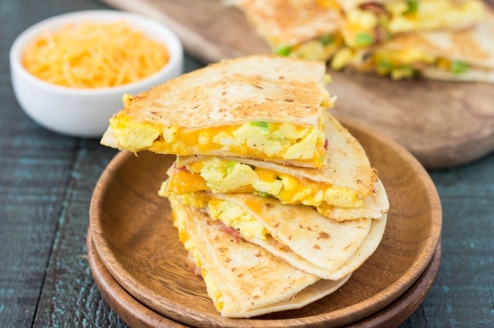 eggs and avocado, between tortillas, easy brunch recipes, wooden plates, wooden table