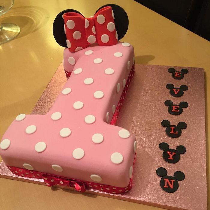 cake in the shape of number one, minnie cake, pink fondant, red bow, black ears, minnie mouse cake decorations
