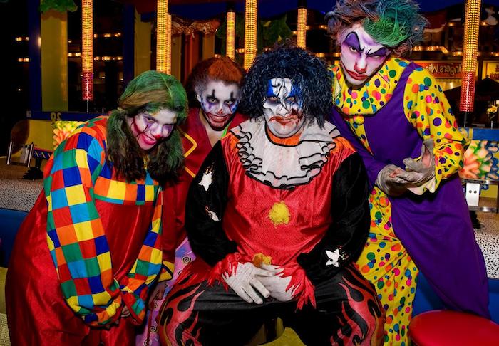 four people, dressed in clown costumes, adult halloween costumes, wearing clown make up