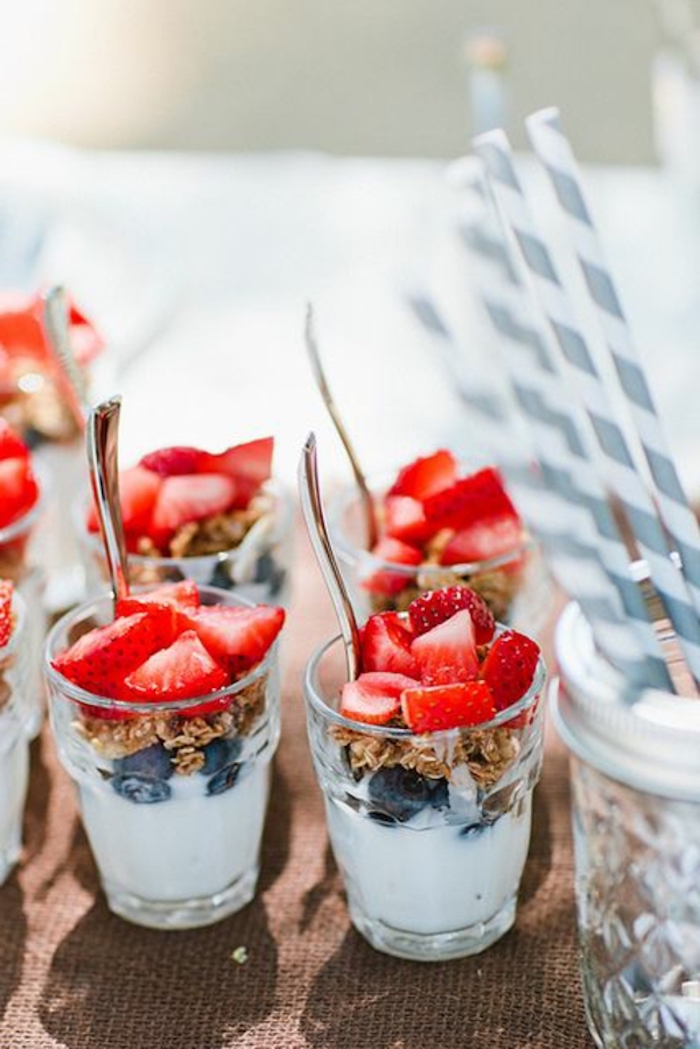 breakfast menu ideas, granola and yoghurt, blueberries and strawberries, silver spoons, paper straws