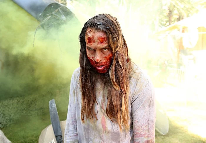woman dressed as a zombie, white torn shirt, bloody face make up, halloween costume ideas for women, brown hair