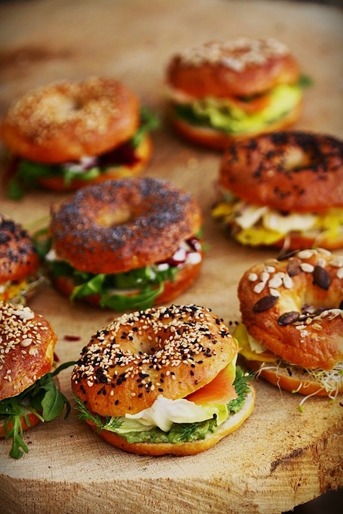 halved bagels, with spinach, salmon and cheese, breakfast potluck, wooden board