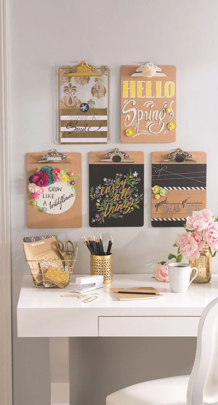 hanging folders, on a white wall, different inspirational quotes, white desk, gold desk accessories, cute office decor