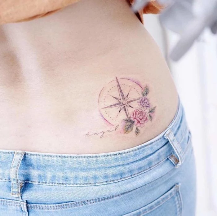hip tattoo, pink and purple roses, woman wearing jeans, compass arrow tattoo, angel cursive text