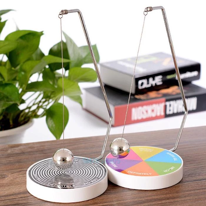 magnetic decision making balls, on a wooden desk, office decor ideas for work, potted plant, two books