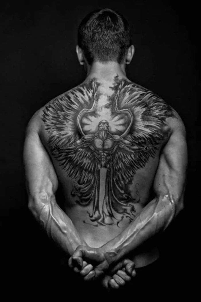 large back tattoo, black background, angel sleeve tattoo, mans body in the middle