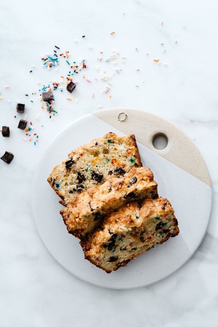 cake with sprinkles, chocolate chips, on white board, marble countertop