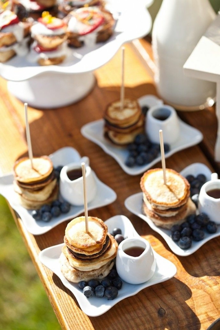 stacks of mini pancakes, blueberries on the side, easy brunch ideas, honey in a jug, wooden table