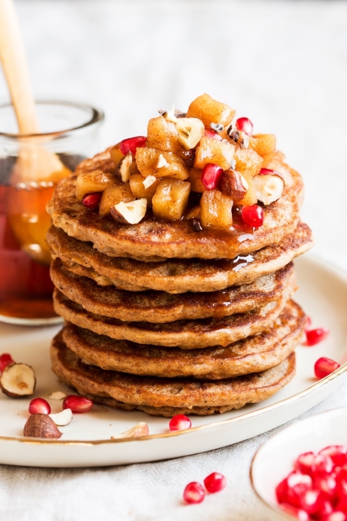 breakfast sides, pomegranate seeds, honey and nuts, white plate, banana and pineapple