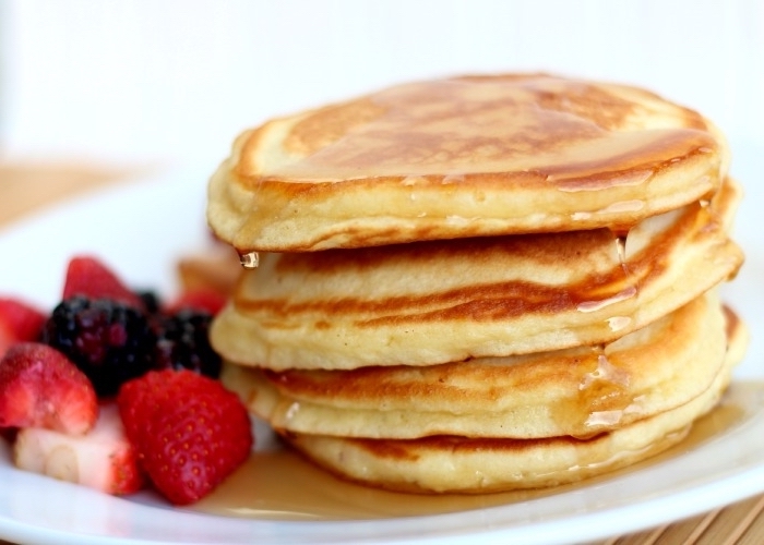 pancakes stack, honey on top, breakfast sides, strawberries and blackberries, white plate