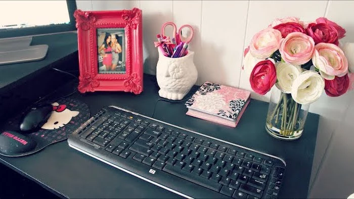black desk, flower bouquet, work office decor, pink photo frame, hello kitty mouse pad, owl pencil holder