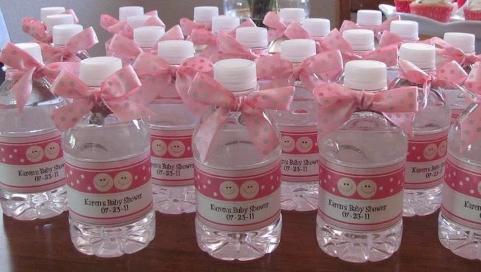 pink and gold baby shower, water bottles, party favors, pink satin ribbons, wooden table