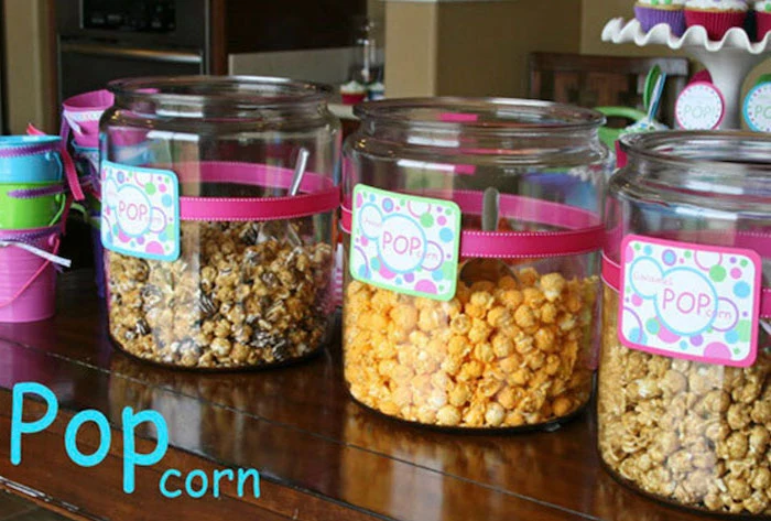 glass jars, full of popcorn, ready to pop, pink and gold baby shower, wooden table