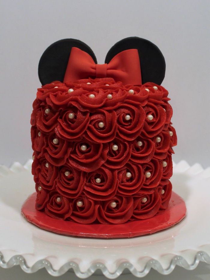red frosting, white pearls, white cake stand, minnie mouse cake topper, red bow