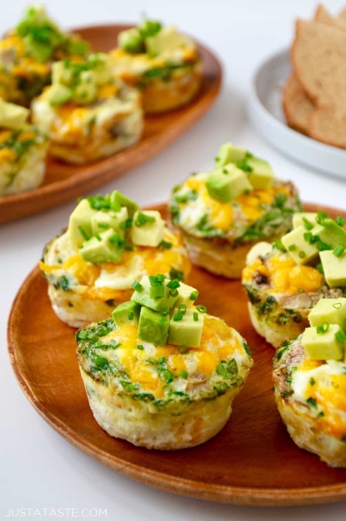 egg muffins, brunch ideas for a crowd, chopped avocados on top, wooden plates, white table