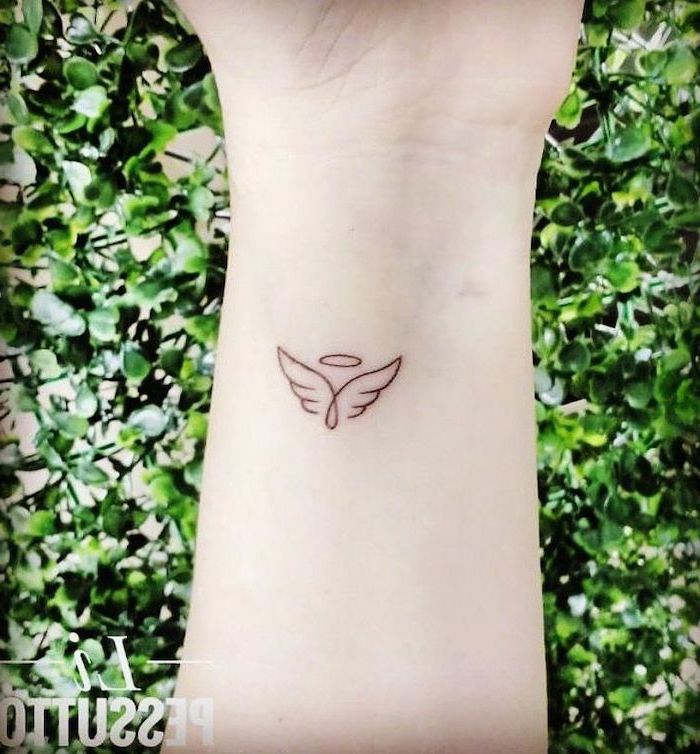 small wrist tattoo, angel tattoos for men, small angel wings, green bushes in the background