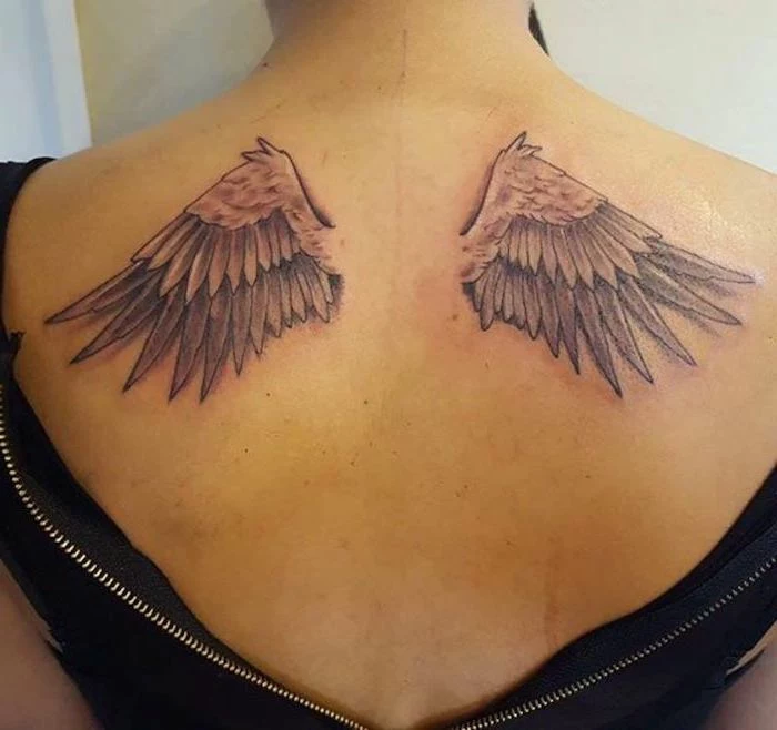 woman with black top, back tattoo, angel wings, angel tattoos for men, white background