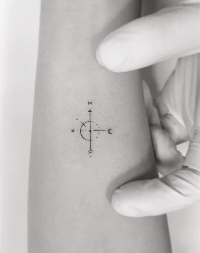 small tattoo, forearm tattoo, simple compass tattoo, black and white photo, rubber gloves