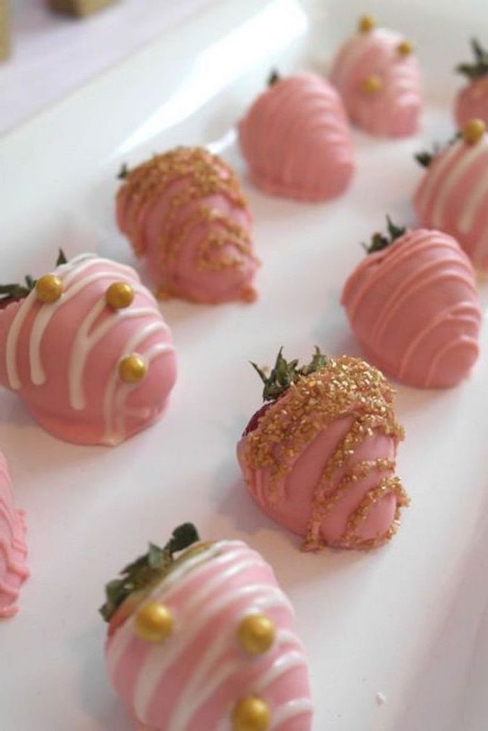 whole strawberries, covered in pink frosting, places to have a baby shower, on white plate