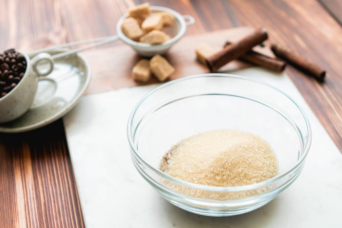 sugar and instant coffee mixed together in glass bowl, cloud coffee recipe, placed on wooden surface