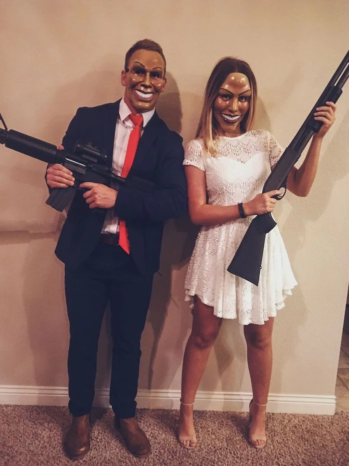 man and woman, dressed as characters from the purge, funny halloween costumes, suit and white dress, holding rifles