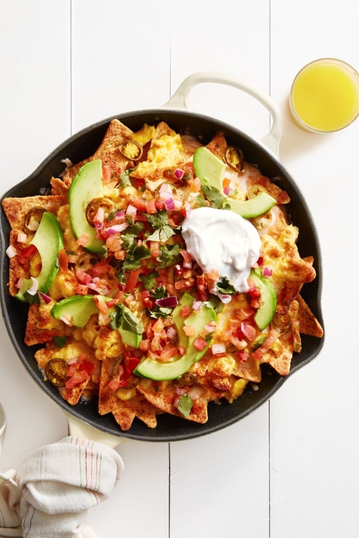 nachos in a pan, vegan brunch recipes, tortilla chips, covered in salsa, avocado sliced, sour cream