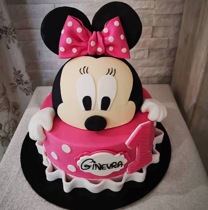 two tier cake, pink fondant, pink bow, black ears, black cake tray, minnie mouse pics