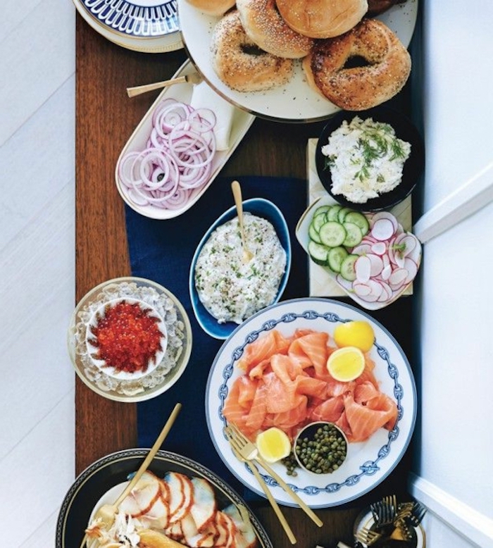 brunch table, chipped onions and cucumbers, salmon fillet, bagels on a plate, different garnish, vegan brunch recipes