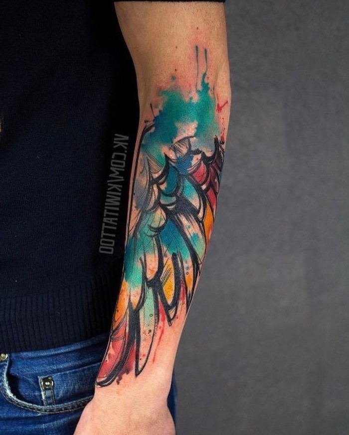 wing tattoo on arm, watercolor tattoo, black top and jeans, grey background, forearm tattoo