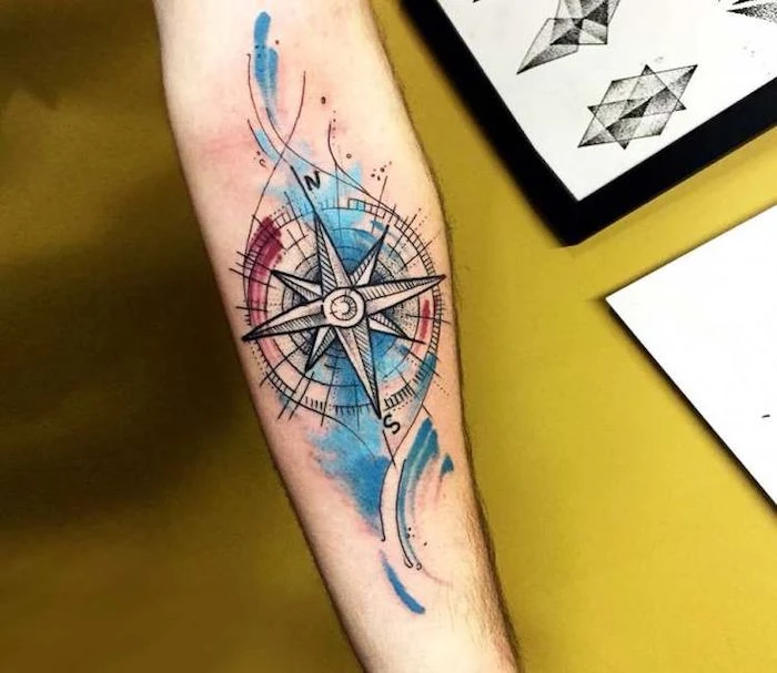 watercolor tattoo, blue and red colors, forearm tattoo, yellow background, compass tattoo forearm