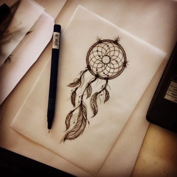 black and white drawing, white paper, wooden table, black pencil, disney dream catcher