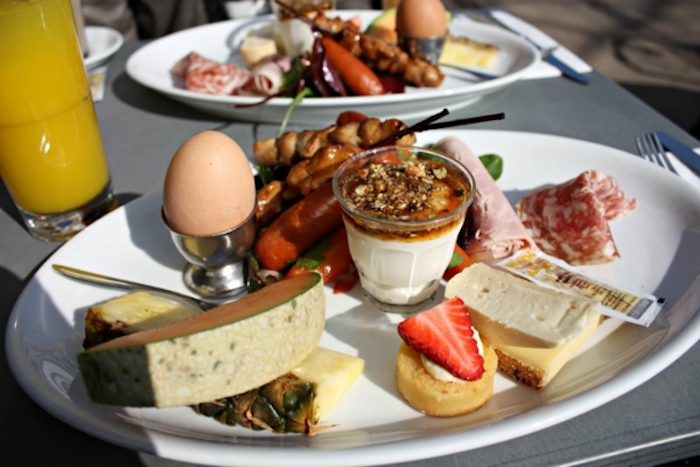 breakfast finger foods, sausages and salami, melon and pineapple, yoghurt and granola, orange juice