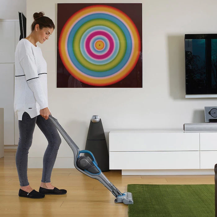 woman cleaning, white blouse, grey trousers, best vacuum cleaner, green carpet, wooden floor