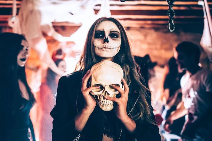 woman holding a skeleton, calavera make up, last minute halloween costumes, long brown hair