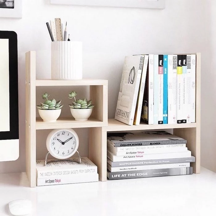 wooden desk organiser, ideas for decorating your office at work, lots of books, potted succulents, pencil holder